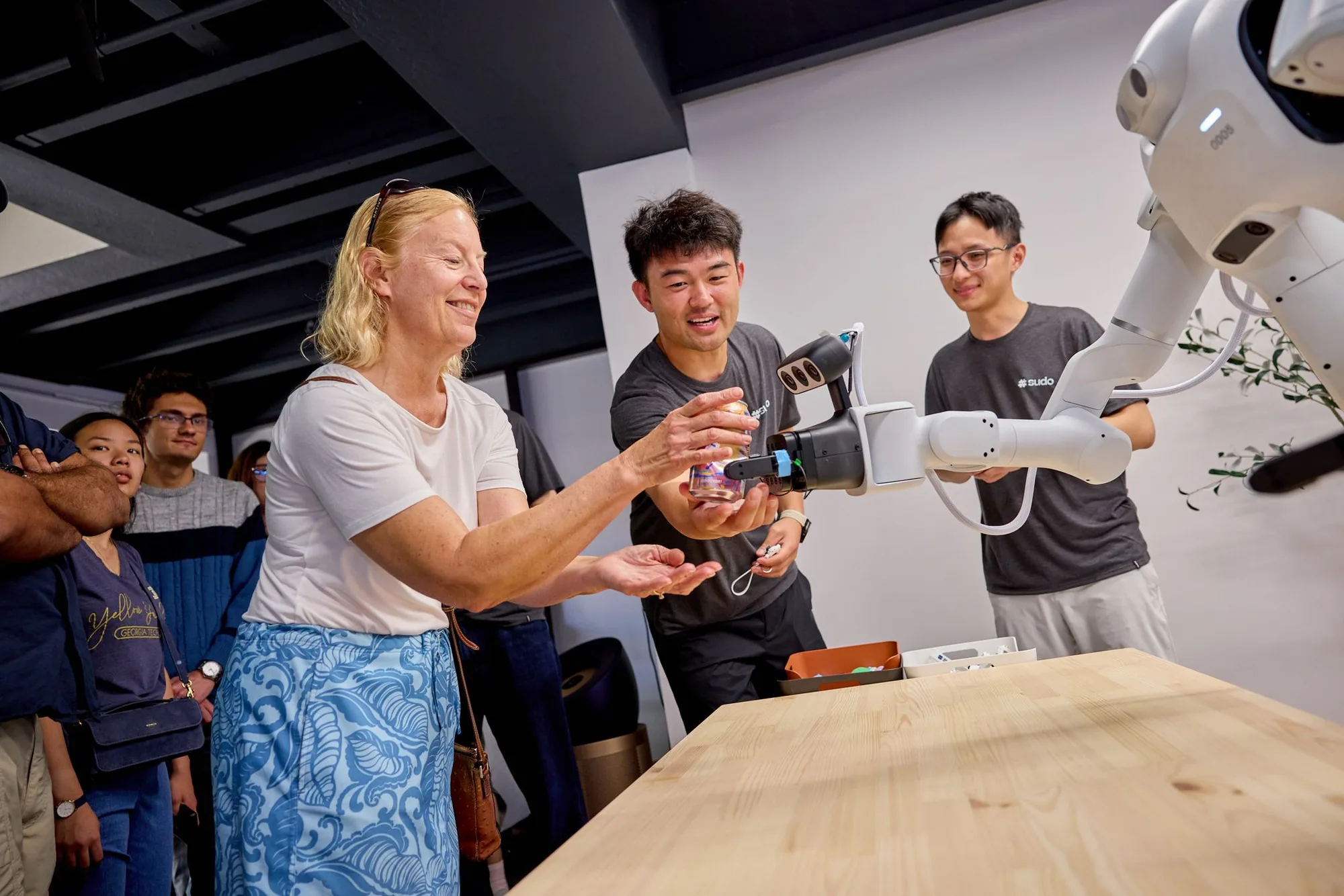 A visitor takes a can from a robot arm during a live demo at bothaus