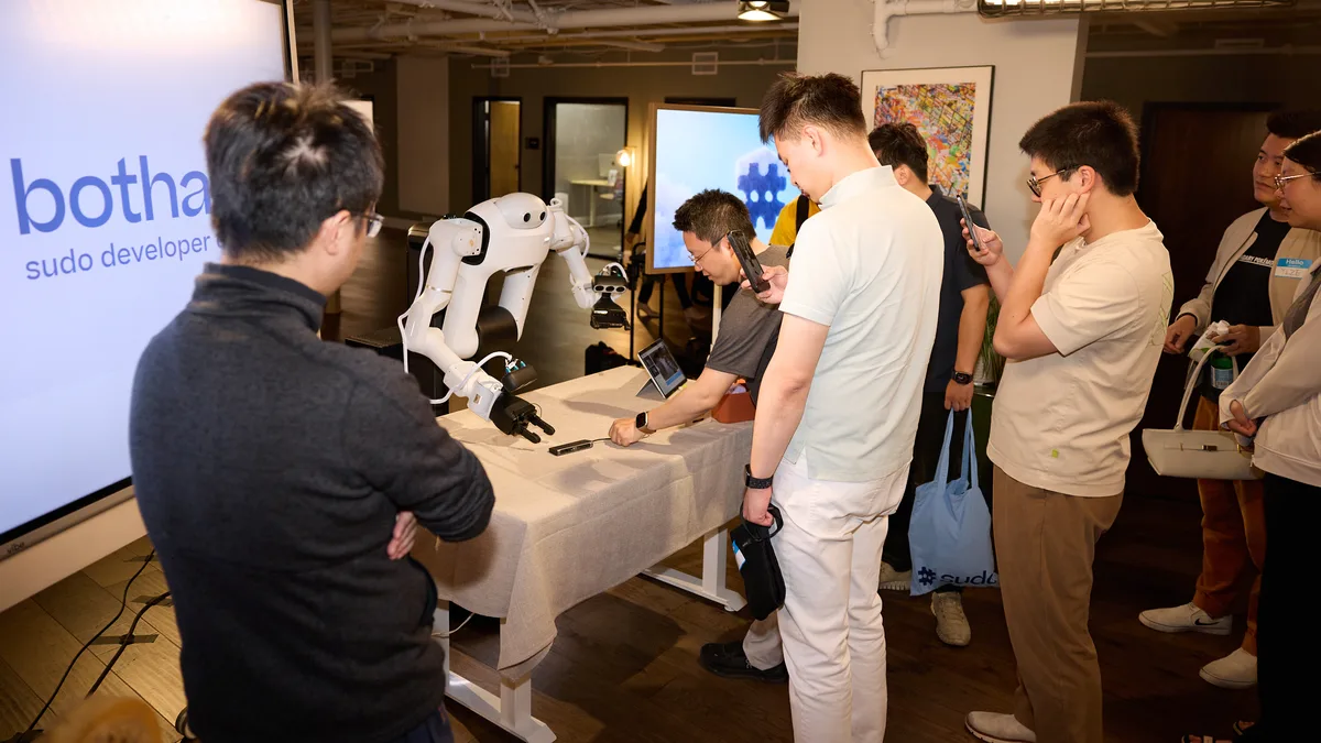 sudo R1 performs a task on a table during a live demo at bothaus